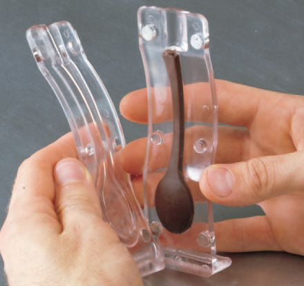 letting the chocolate set and prying the parts of the mold apart. letting the chocolate set and prying the parts of the mold apart.